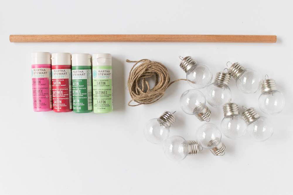 Lights, twine, and paint sit together on a white surface.