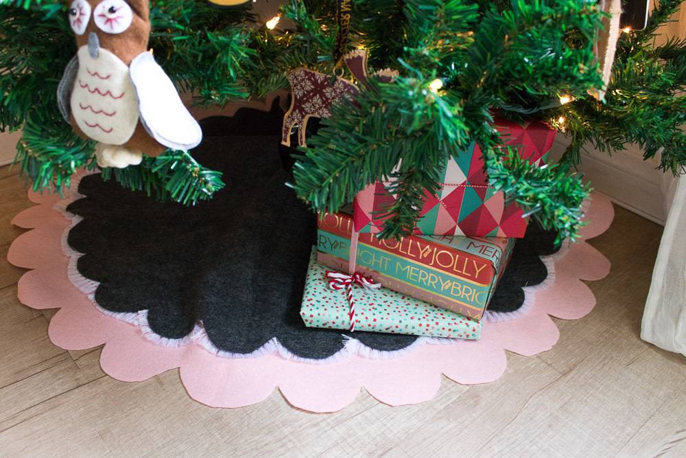 Black and tan scalloped tree skirt and an owl ornament adorn a Christmas tree.