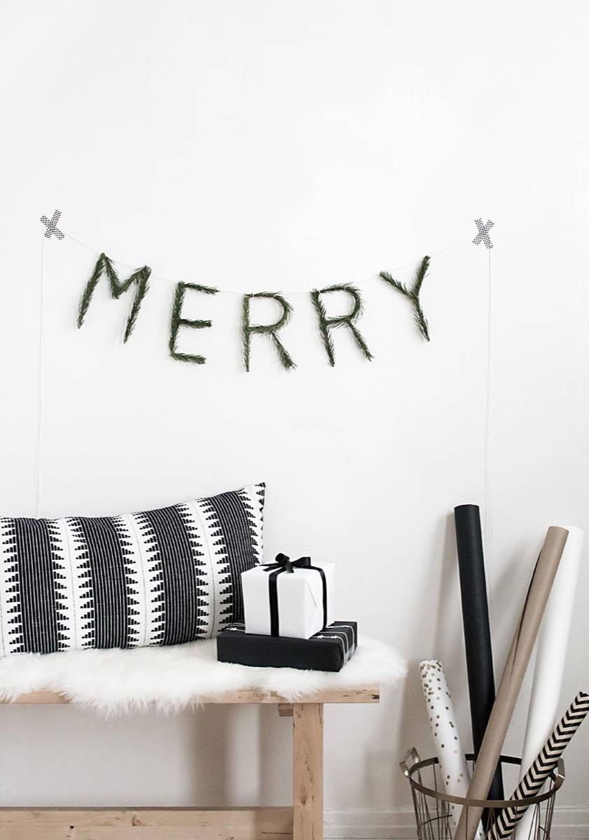 A black wall hanging that says "MERRY".