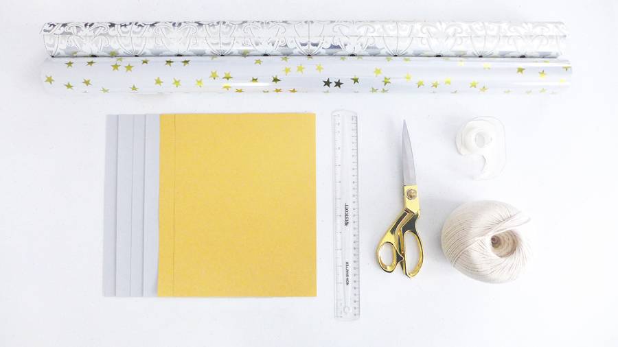 Colored papers, scale, scissor, thread and gift wrappers are in a white background.