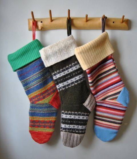 Three striped socks hand from a wooden hanger on the wall.