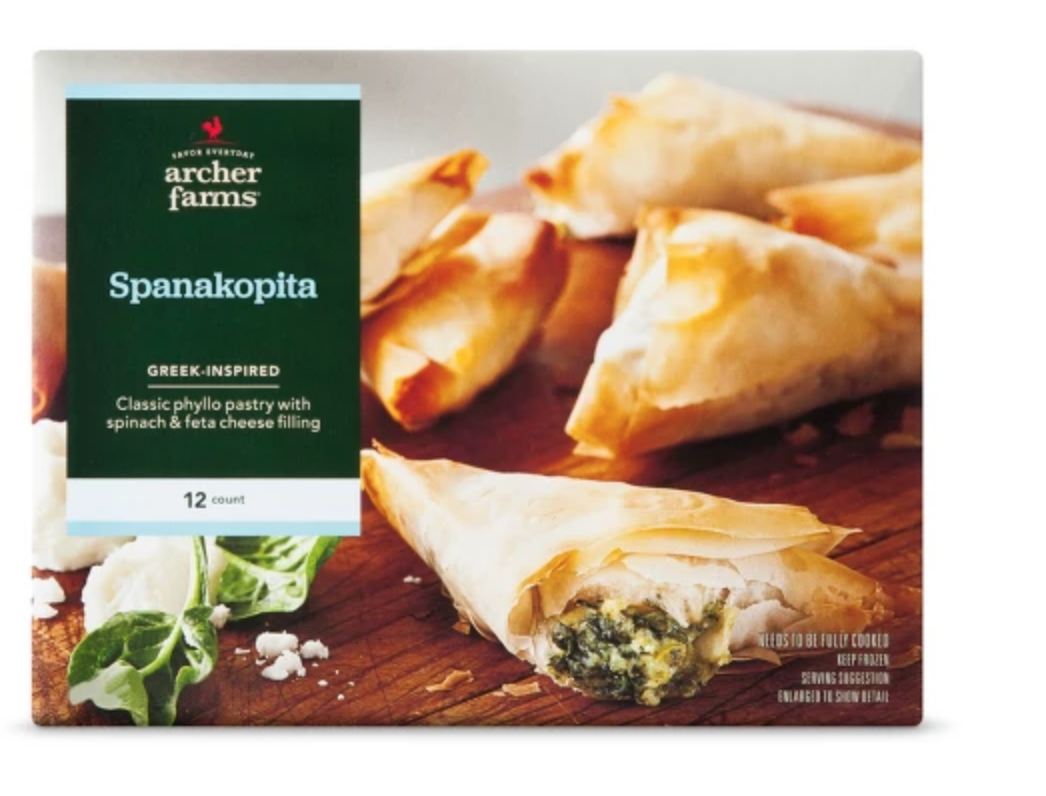 Spanakopita lying on a wooden table with a banner on the left.