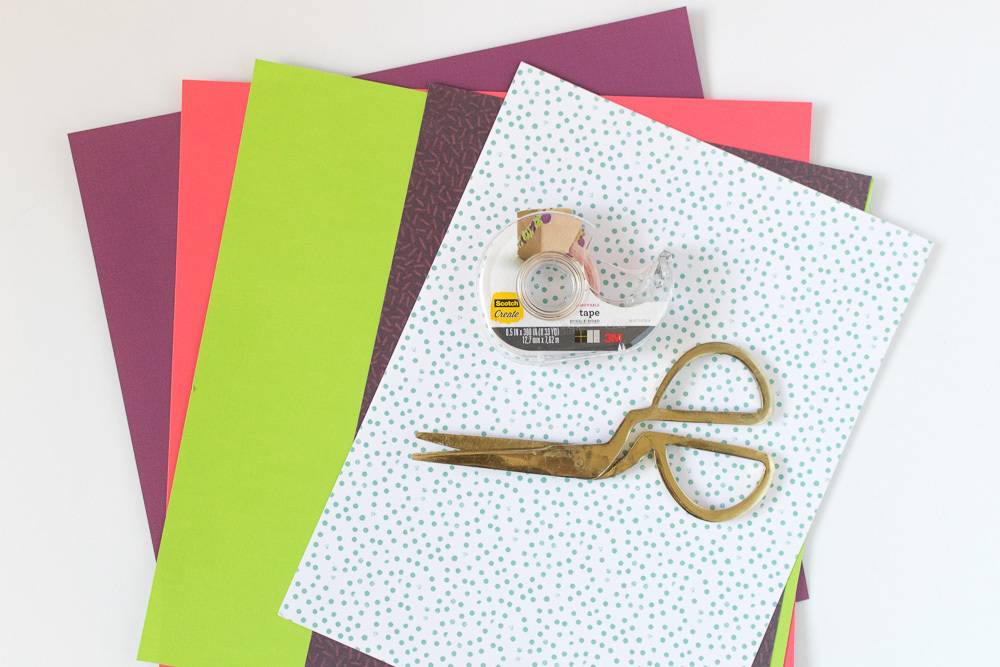gold scissors and tape on top of folders
