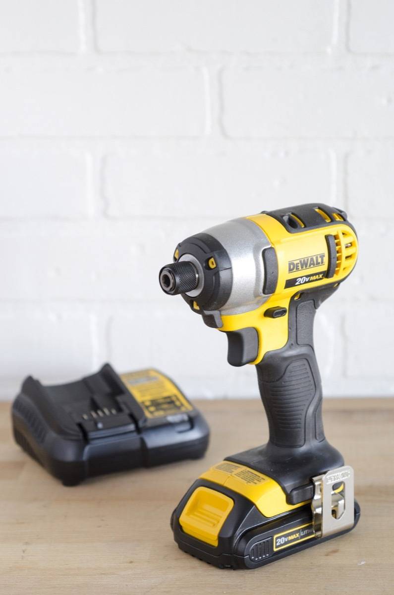 Yellow and black colored cordless impact driver on the table.
