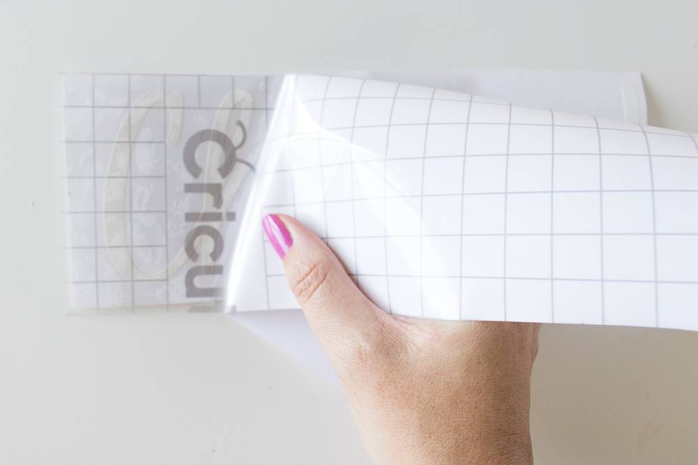 A person holds a white paper label with text on it.