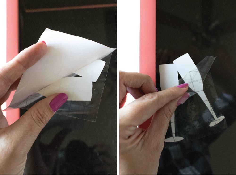 A paper cutout of wine glasses being held up by a hand