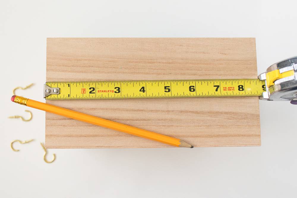 A pencil and a ruler on a wooden piece of wood.