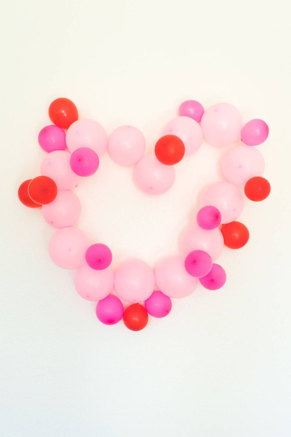 A heart made of different colors of pink balloons.