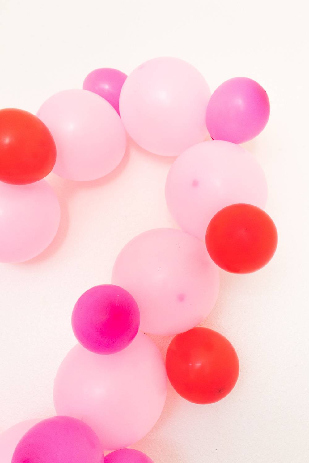 Part of a heart-shaped balloon display, featuring pale pink, violet and red.