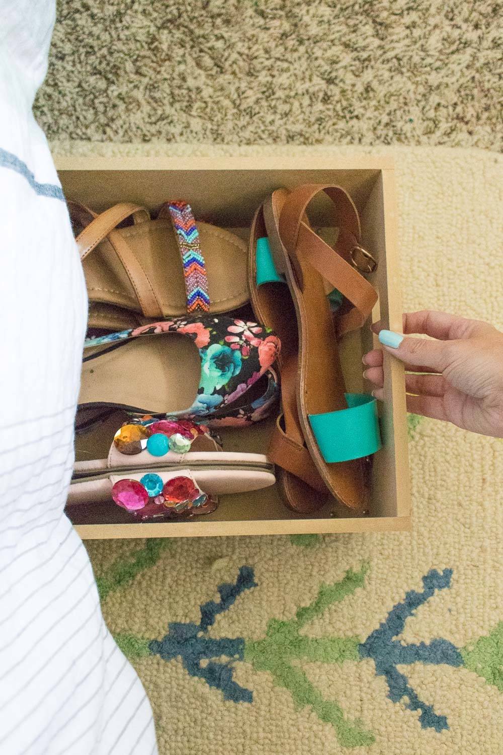 A drawer contains several pairs of colorful sandals.
