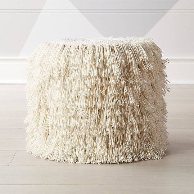 Cylinder shaped white color pouf on the floor.