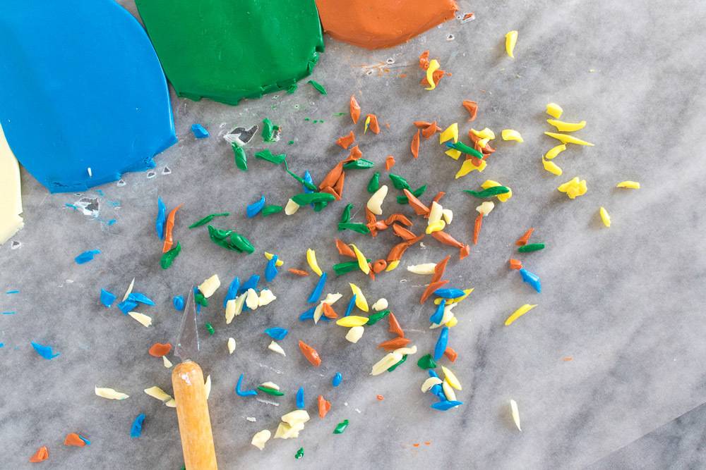 Small pieces of clay sitting on the ground next to each other next to a wooden stick.