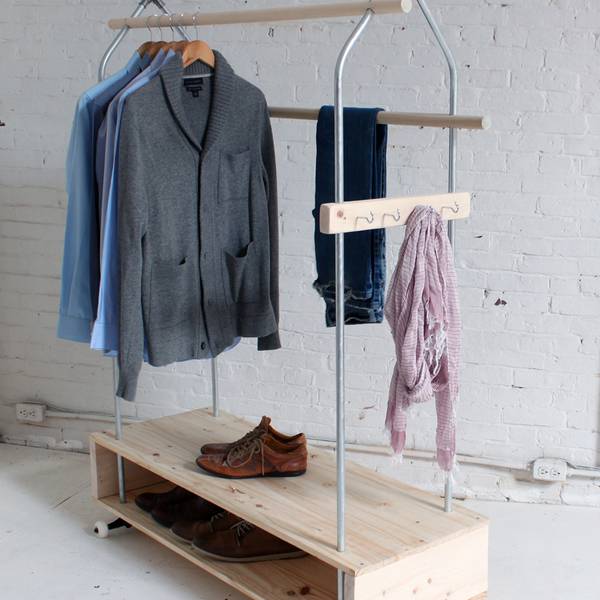 Clothing is hanging on a rack in a white room.