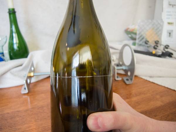 A dark green liqour bottle with a scratch around it.