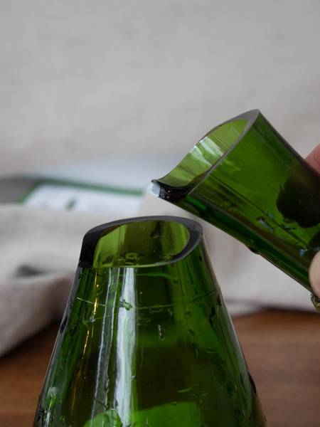 A green bottle broken at the neck.