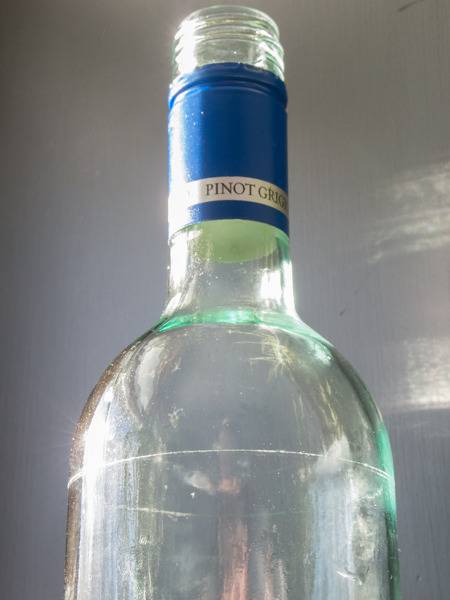 A bottle with a blue label around the neck.