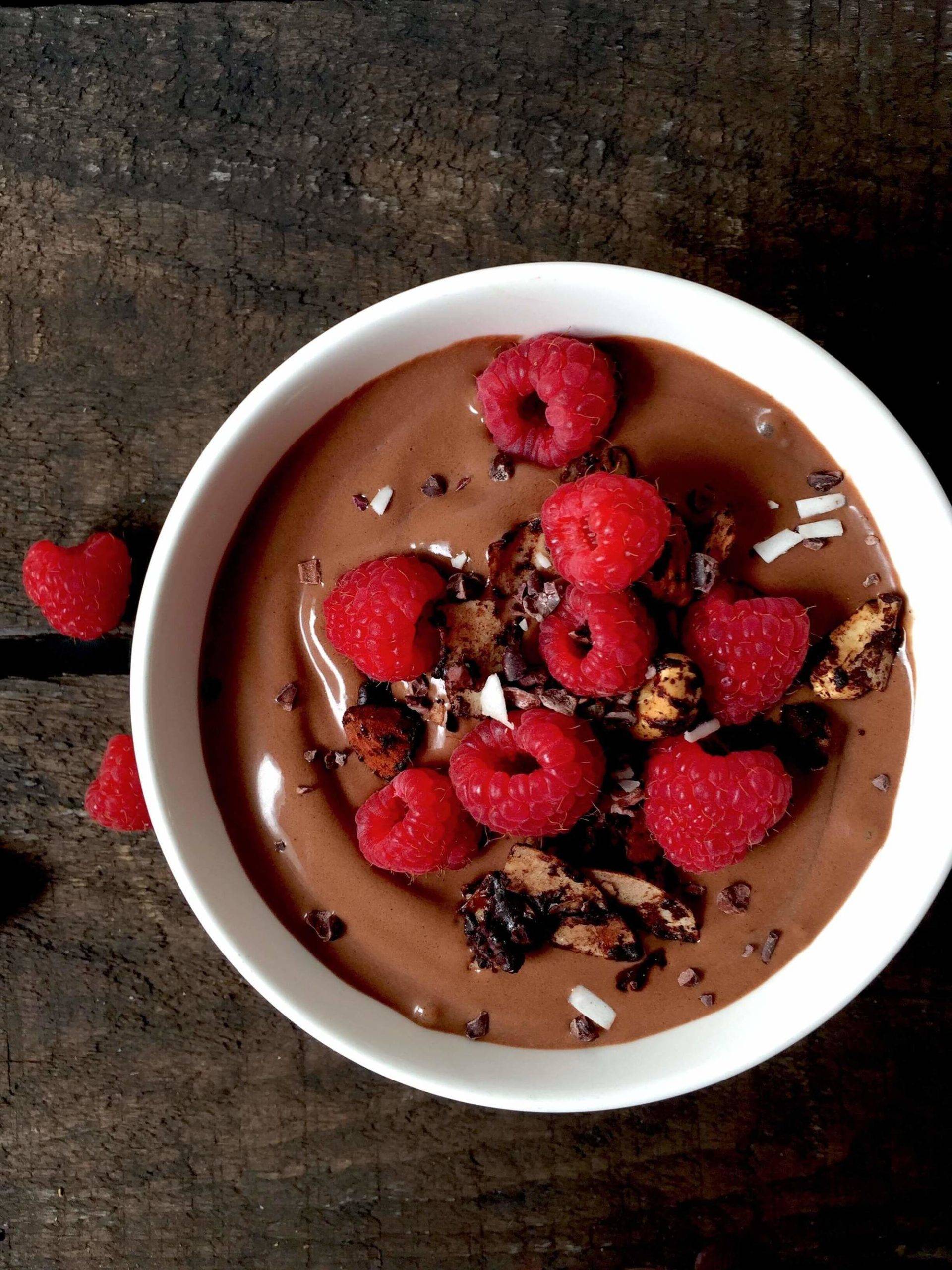 a bowl of chocolate pudding with raspberries in it