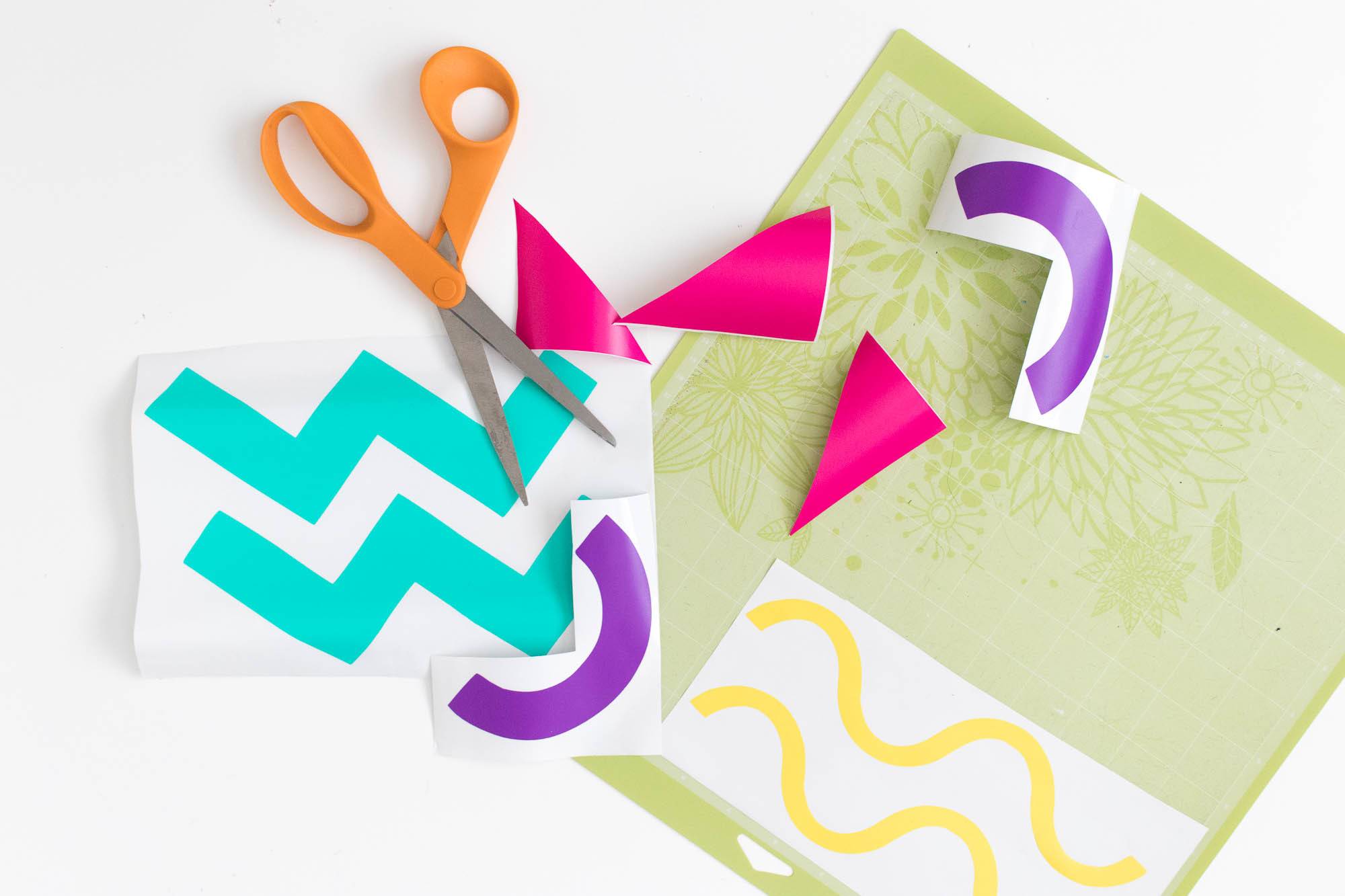 Paper with zig zags and wavy lines with scissors on top.