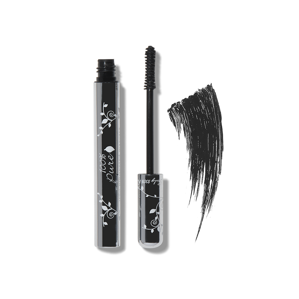 Small black makeup brushes lay next to an eyelash.