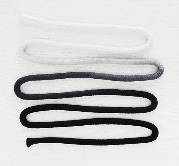 A rope is displayed curled back and forth and graduating from white to black.