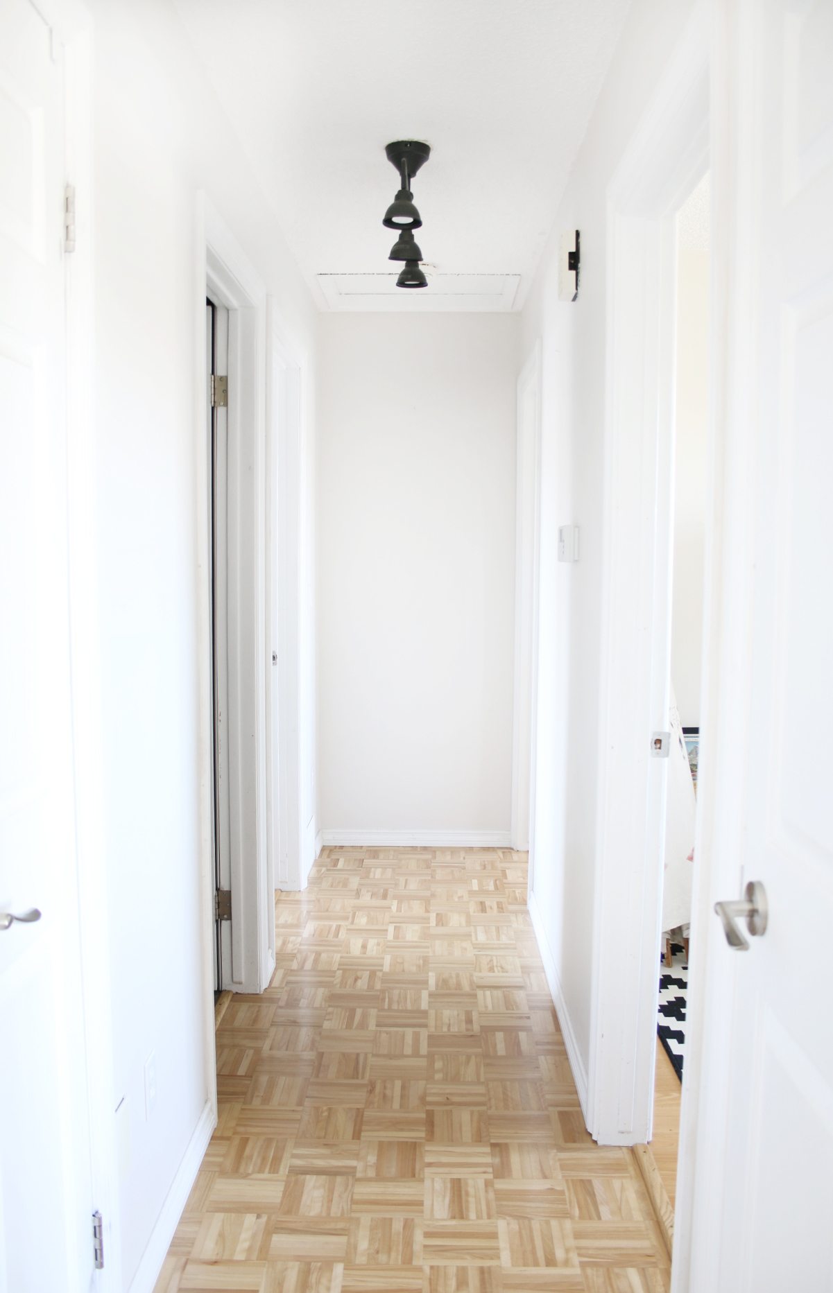 Interior hallway with brown tile floor and white walls.