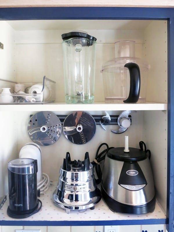 Store food processor blades on a magnetic knife strip inside a cabinet