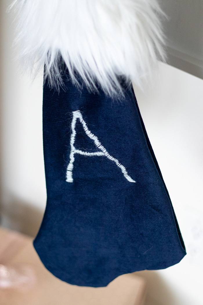 Navy blue stocking with white fur and the letter A embroidered on the front.