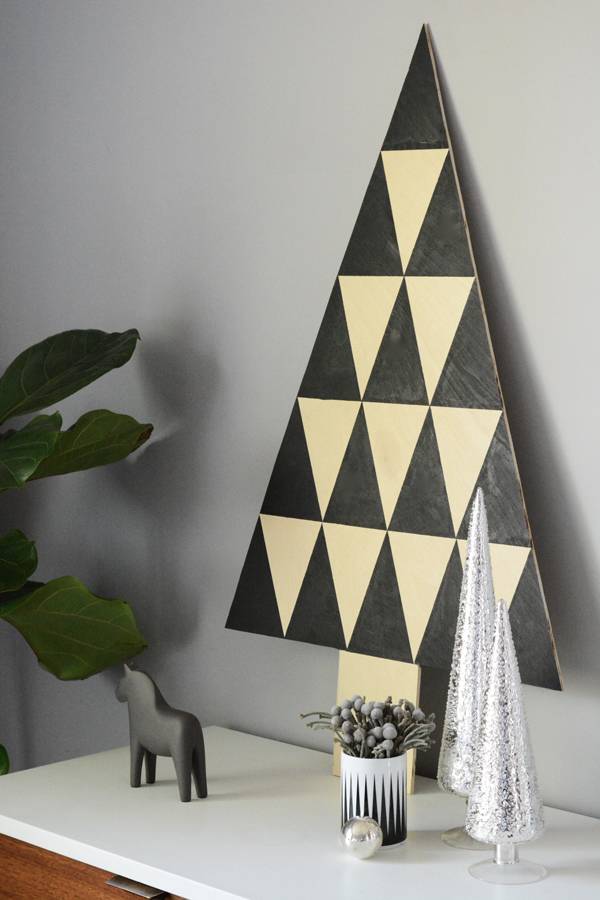 Black and white triangle shaped wall decoration hanging on a silver painted wall.