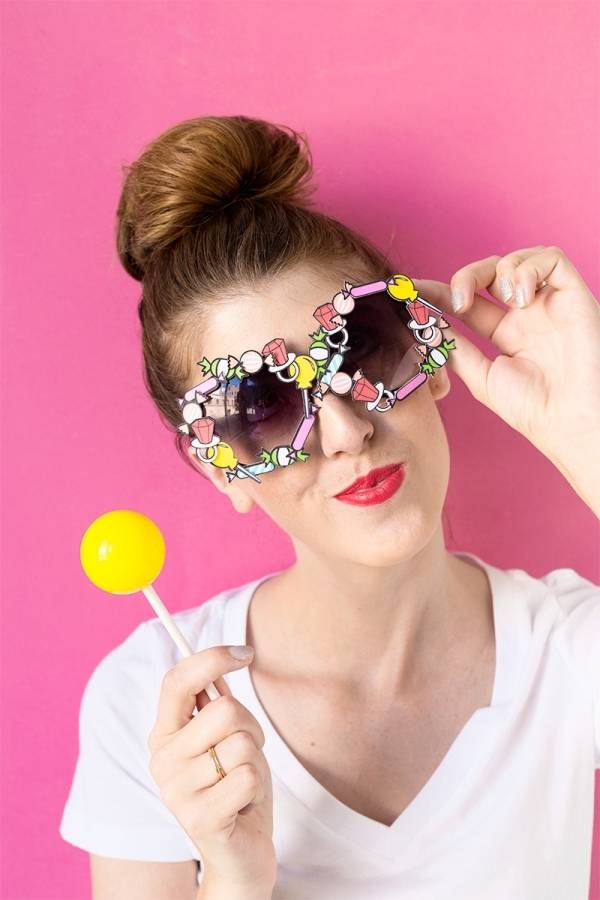 Woman wearing a colorful cooling glass and holding a candy in her hand.