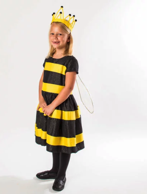 A young blonde girl wearing a black tipped yellow crown and a black and yellow striped dress with black stockings and shoes.