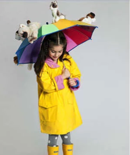 A girl in a yellow raincoat is holding an umbrella with animals on it.