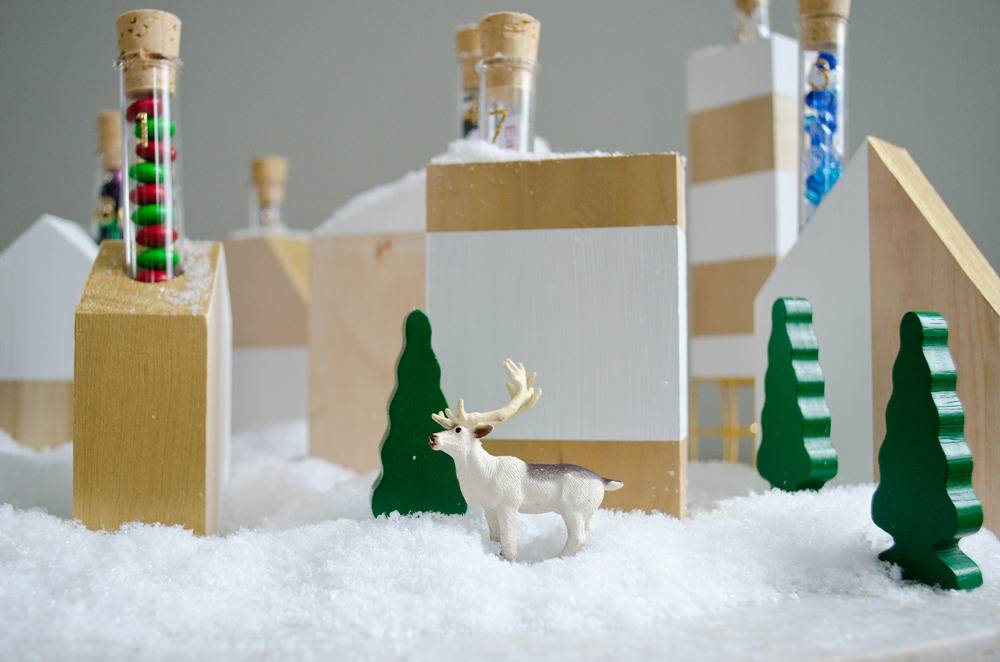 A small miniature set shows a white deer near pine trees and wooden blocks.