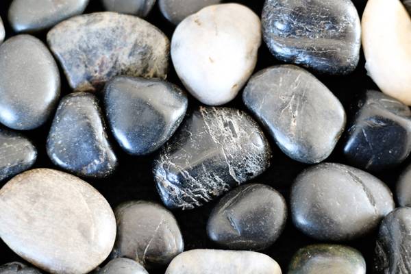 Black, grey and white stones lying adjacent to each other.