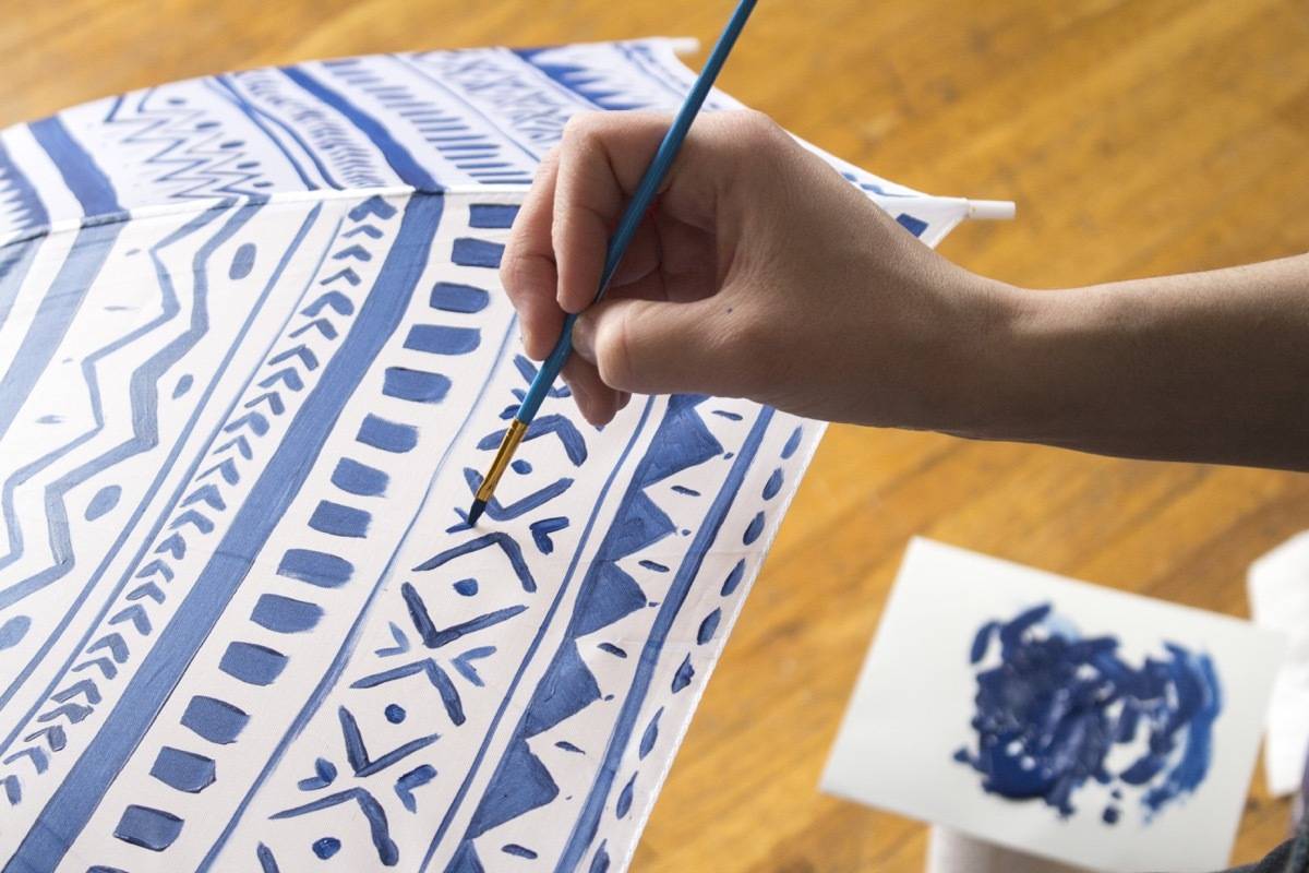 A person has used a brush with blue paint to paint on a white surface.