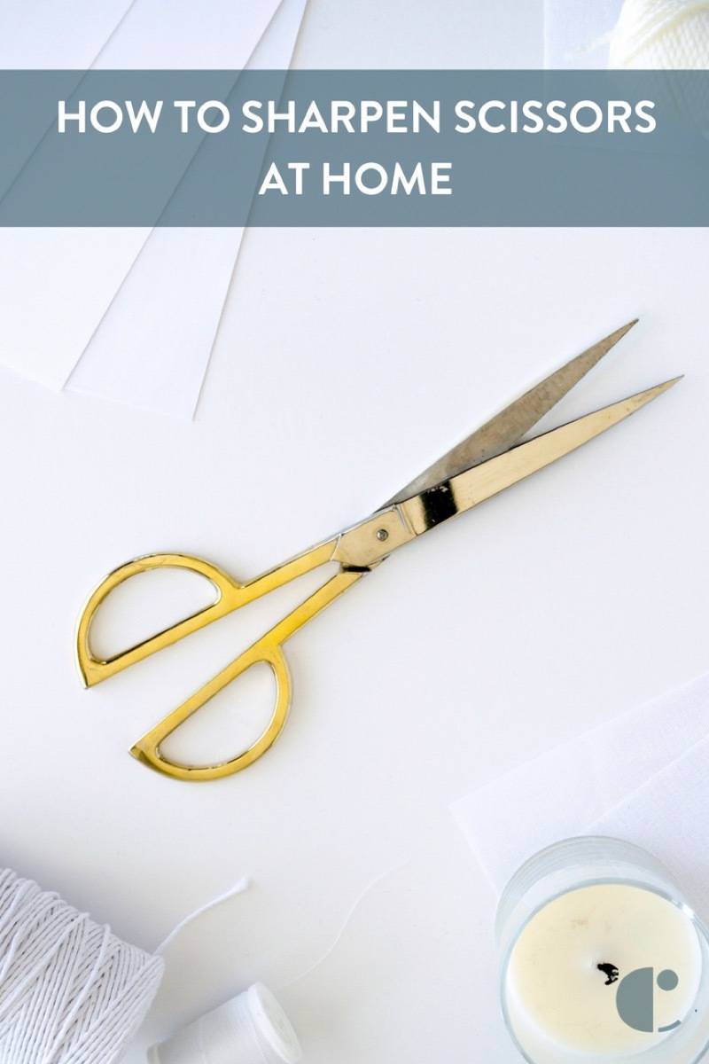 A pair of yellow handed scissors is sitting on a white surface.