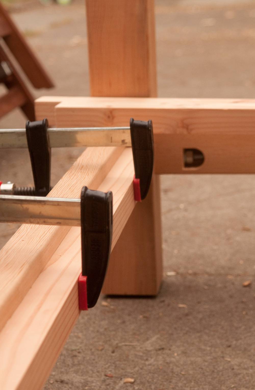 Two clamps holding together a piece of wood.