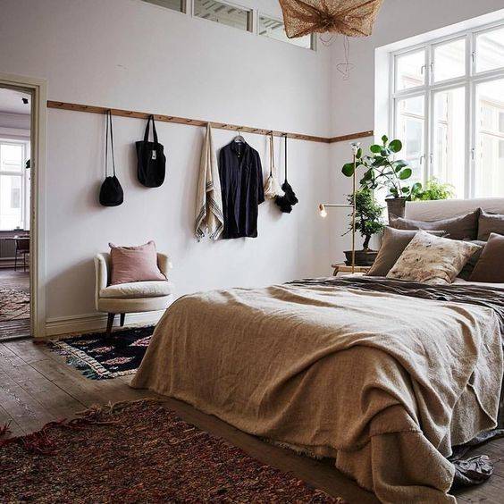 Use a row of hooks as functional wall decor in a bedroom