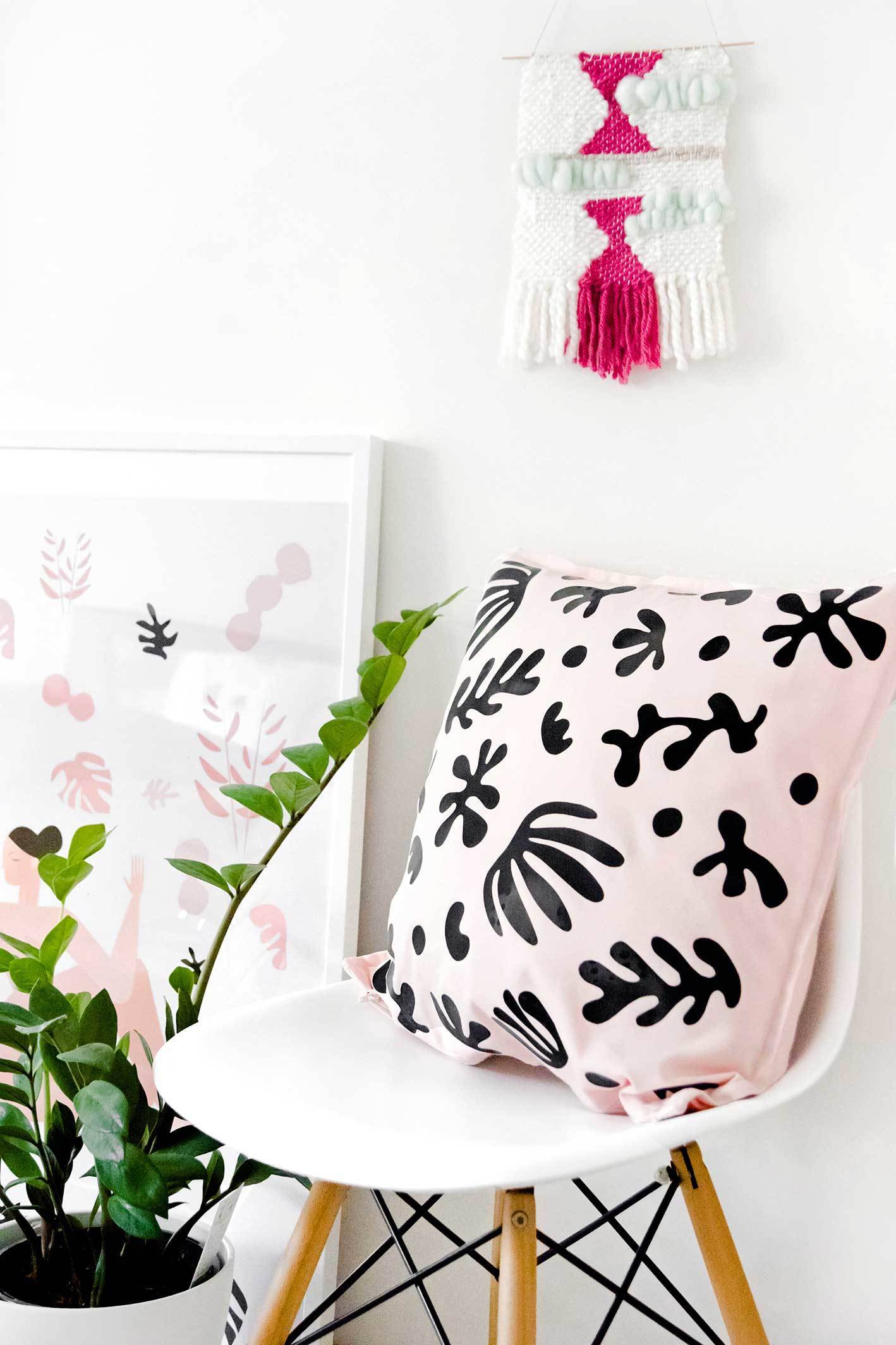 A pink pillow with funky black vinyl decals