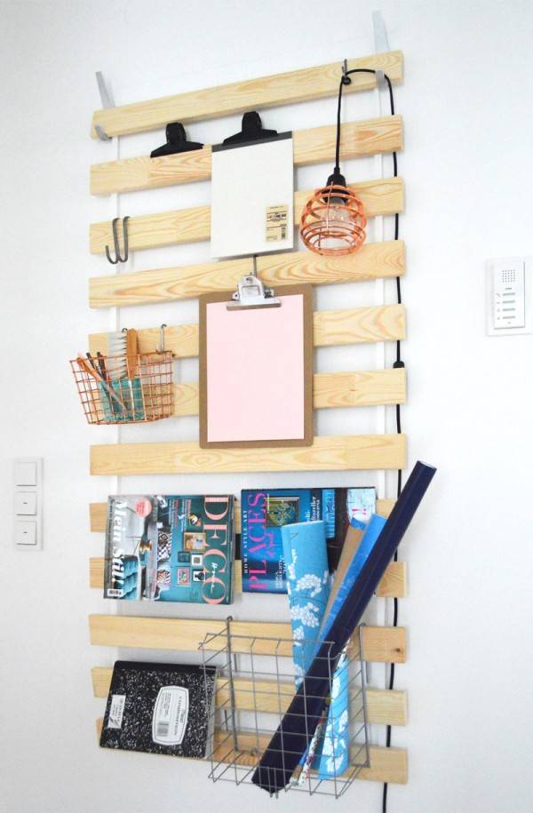 Wooden wall organizer with office related items resting on it.