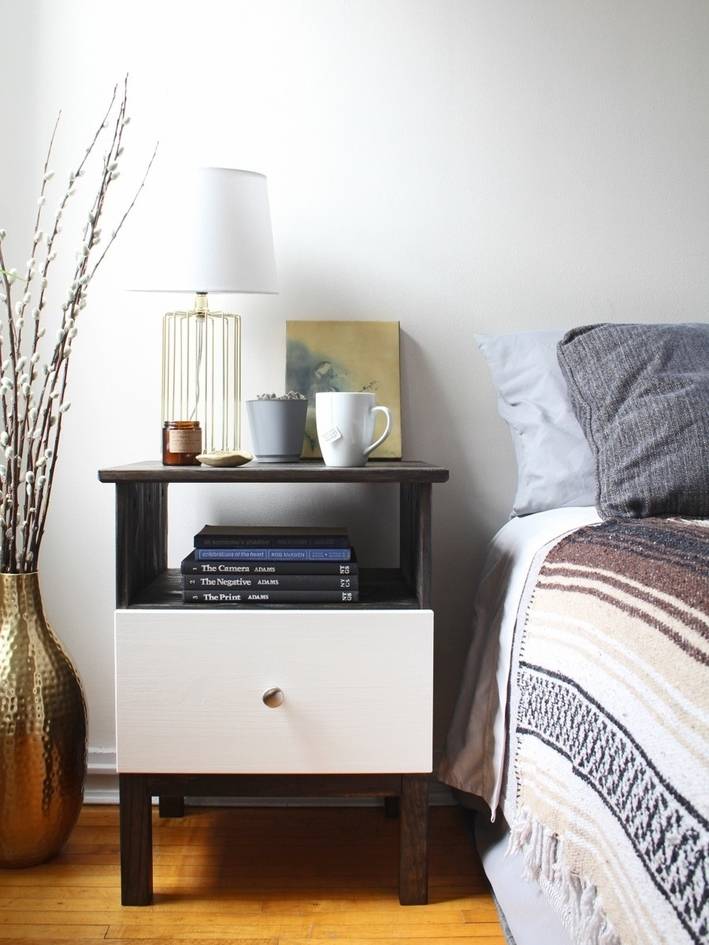 Items sit on a bedside table near a table with striped sheets.