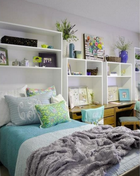 Aqua, green, and white dorm room with bed, desks, and extra shelving.
