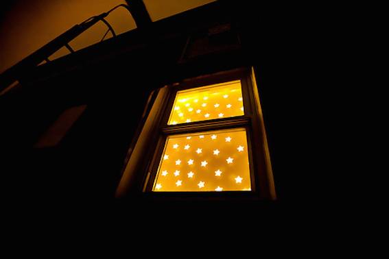 A window shows a yellow light with stars on it.