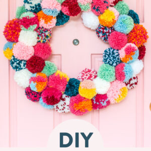 colorful pom pom wreath on a pink door