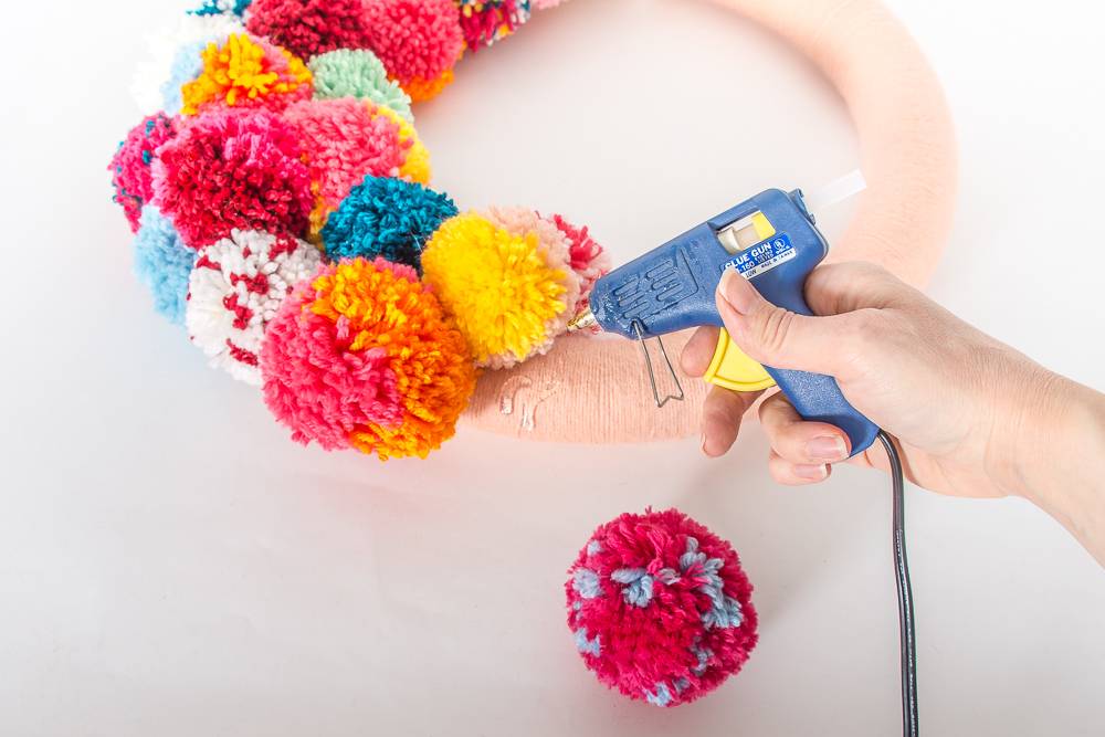 Glue the pom-poms to the wreath form