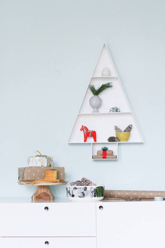 Animal and plant figurines stacked on Christmas tree shaped shelf.
