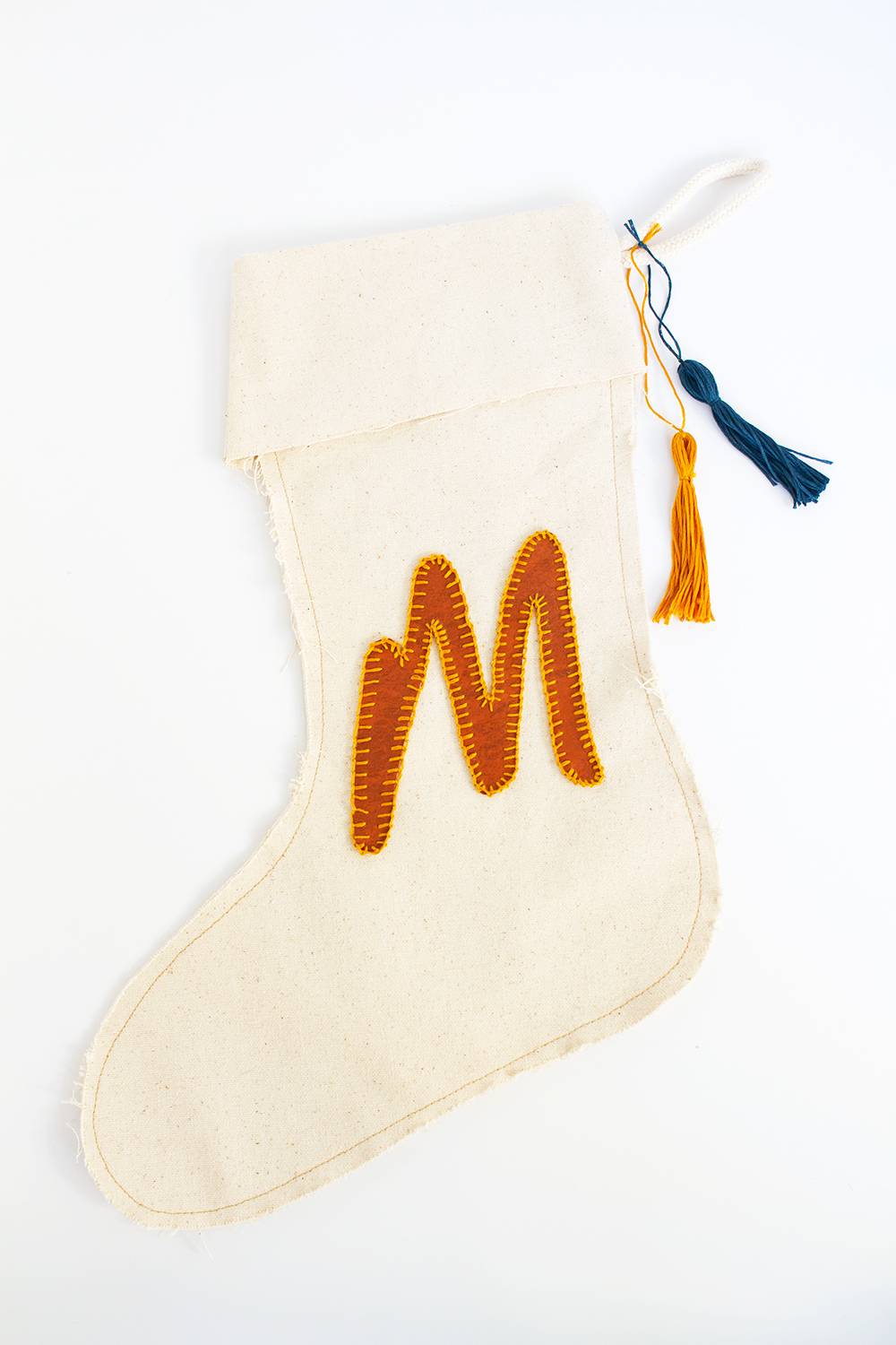 A natural colored stocking with the letter M in orange.