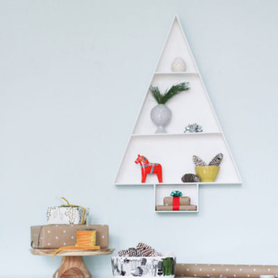 A shelf with side walls is in the shape of a Christmas tree.