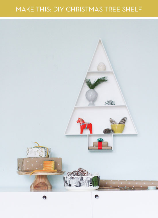 A shelf with side walls is in the shape of a Christmas tree.