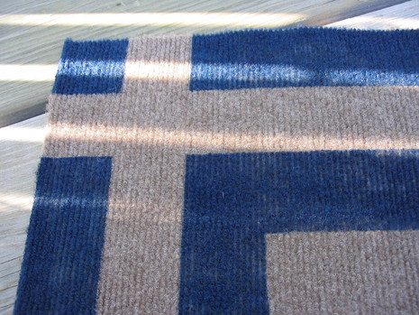 A blue and grey rug sits on the wooden floor.