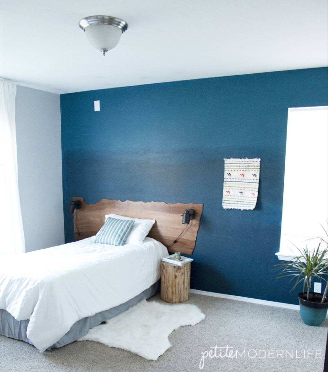 Blue and white bedroom with sheepskin rug on carpeted floor